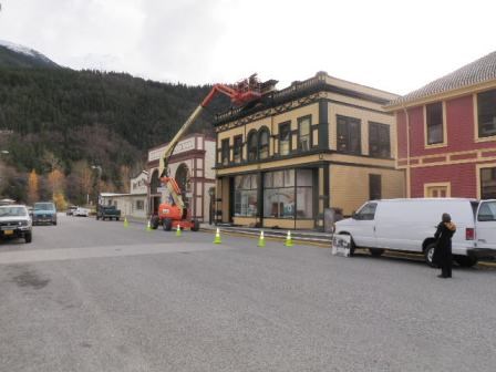 Modern photo of a crane raised next to a historic building