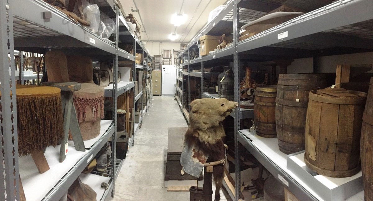 Color photo of a row of gray shelves holding various museum collection artifacts Color photo of a row of gray shelves holding various museum collection artifacts