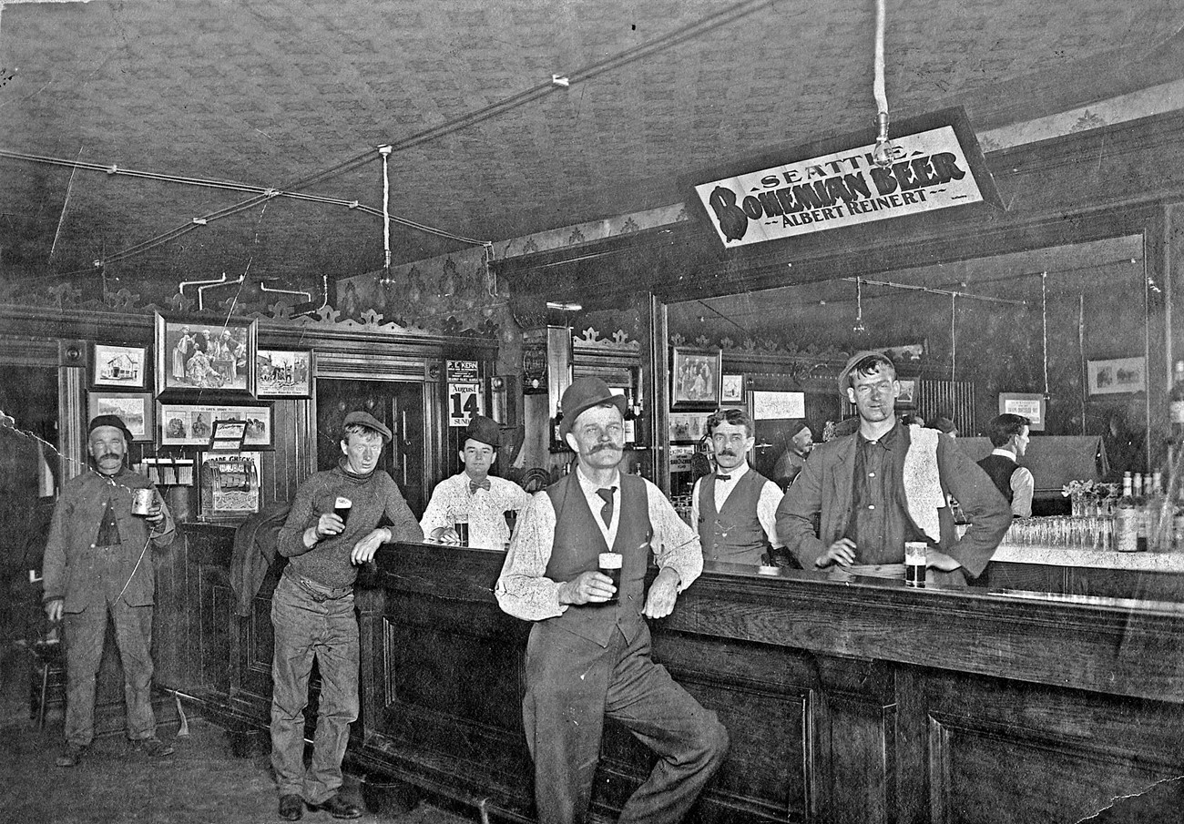 six men stand in a bar