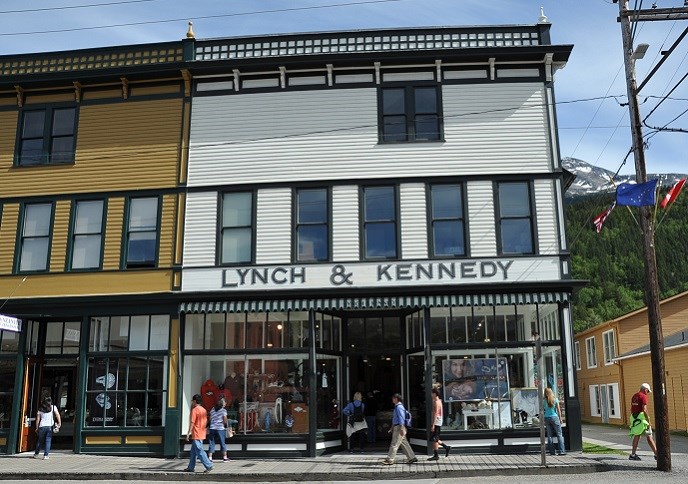 Modern photo of large, multistory white building with painted sign reading "Lynch & Kennedy"