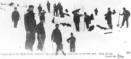 Black and white photo of men holding shovels standing in a snowfield