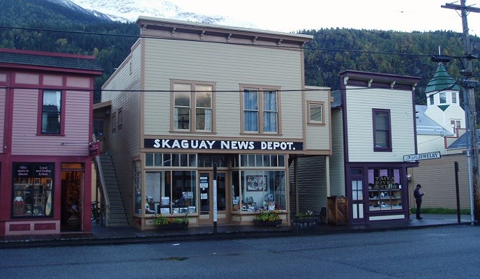 Colorful buildings containing businesses line a street. Colorful buildings containing businesses line a street.
