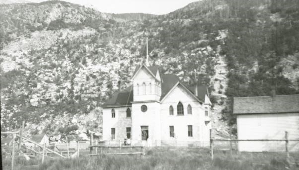 Three story building in front of mountain