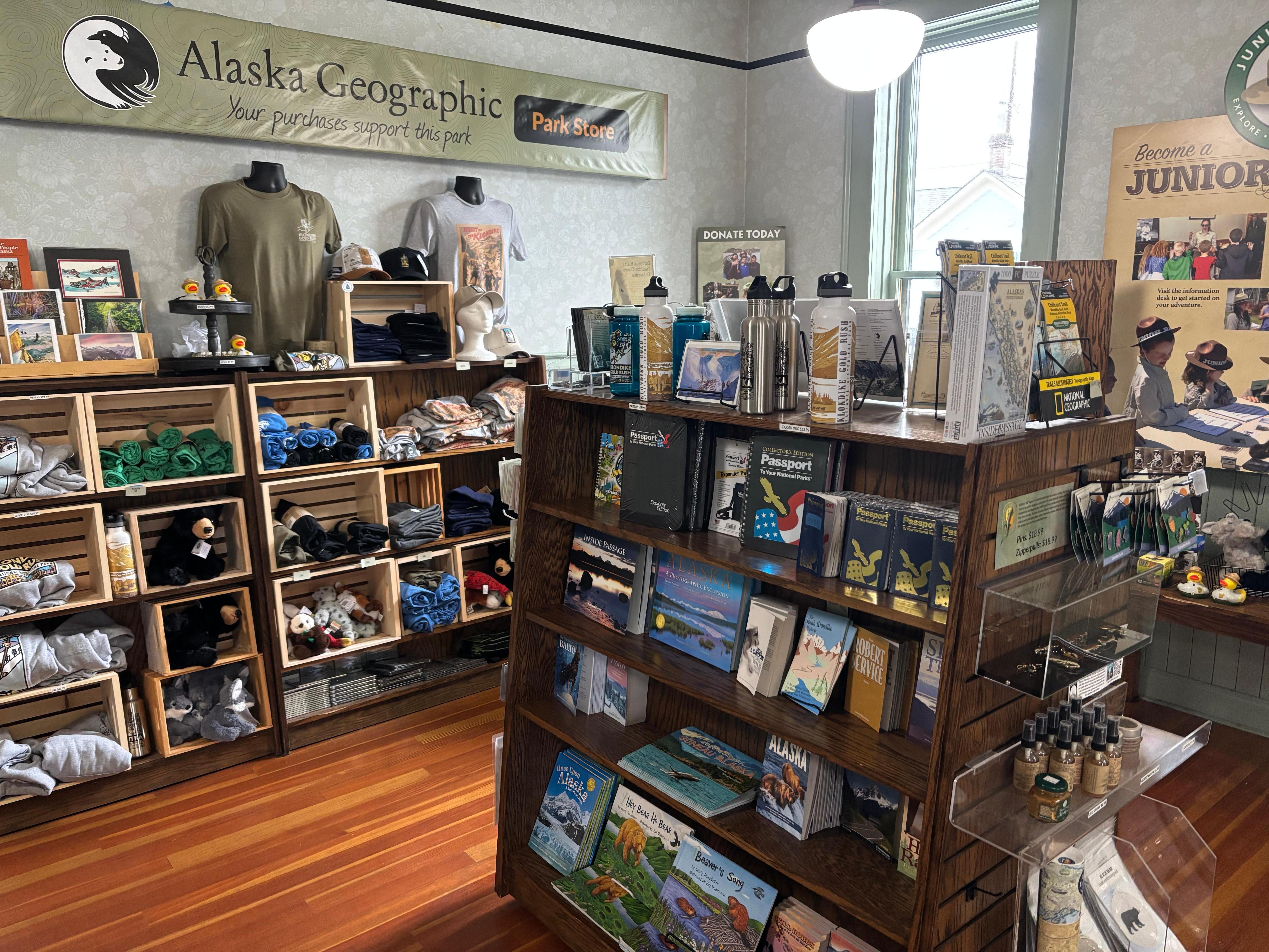 Shelves full of park merchandise with a sign in the background that reads "Alaska Geographic Park Store".