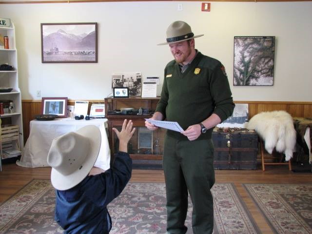 A ranger works with a child in the Junior Ranger Activity Center A ranger works with a child in the Junior Ranger Activity Center