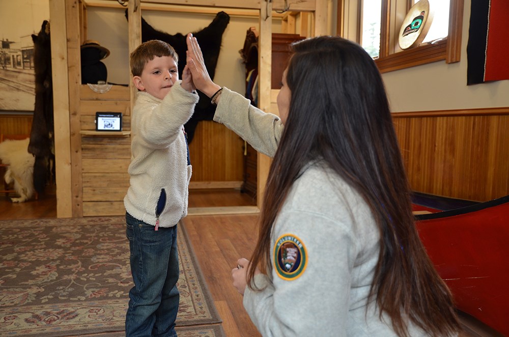 An adult high fives a boy An adult high fives a boy