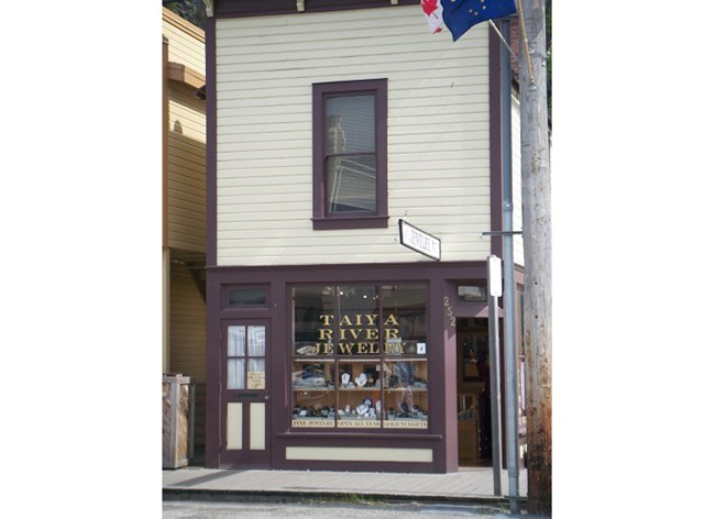 Small two story building, white and brown in color.