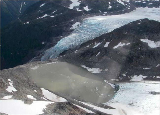 Aerial view of a mountain lake with glacial ice nearby. Aerial view of a mountain lake with glacial ice nearby.