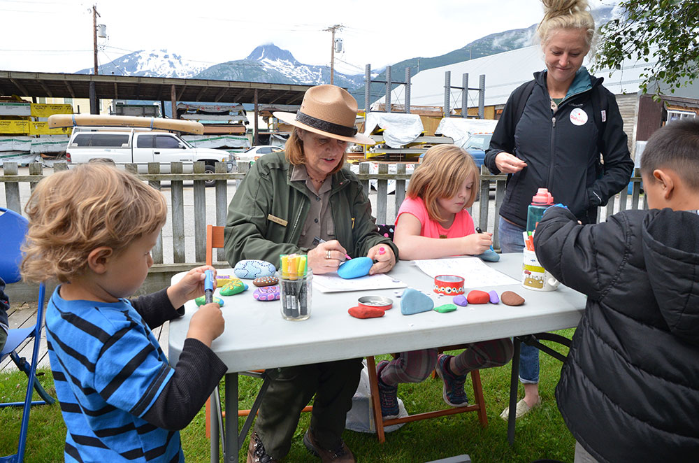 a ranger paints rocks with kids