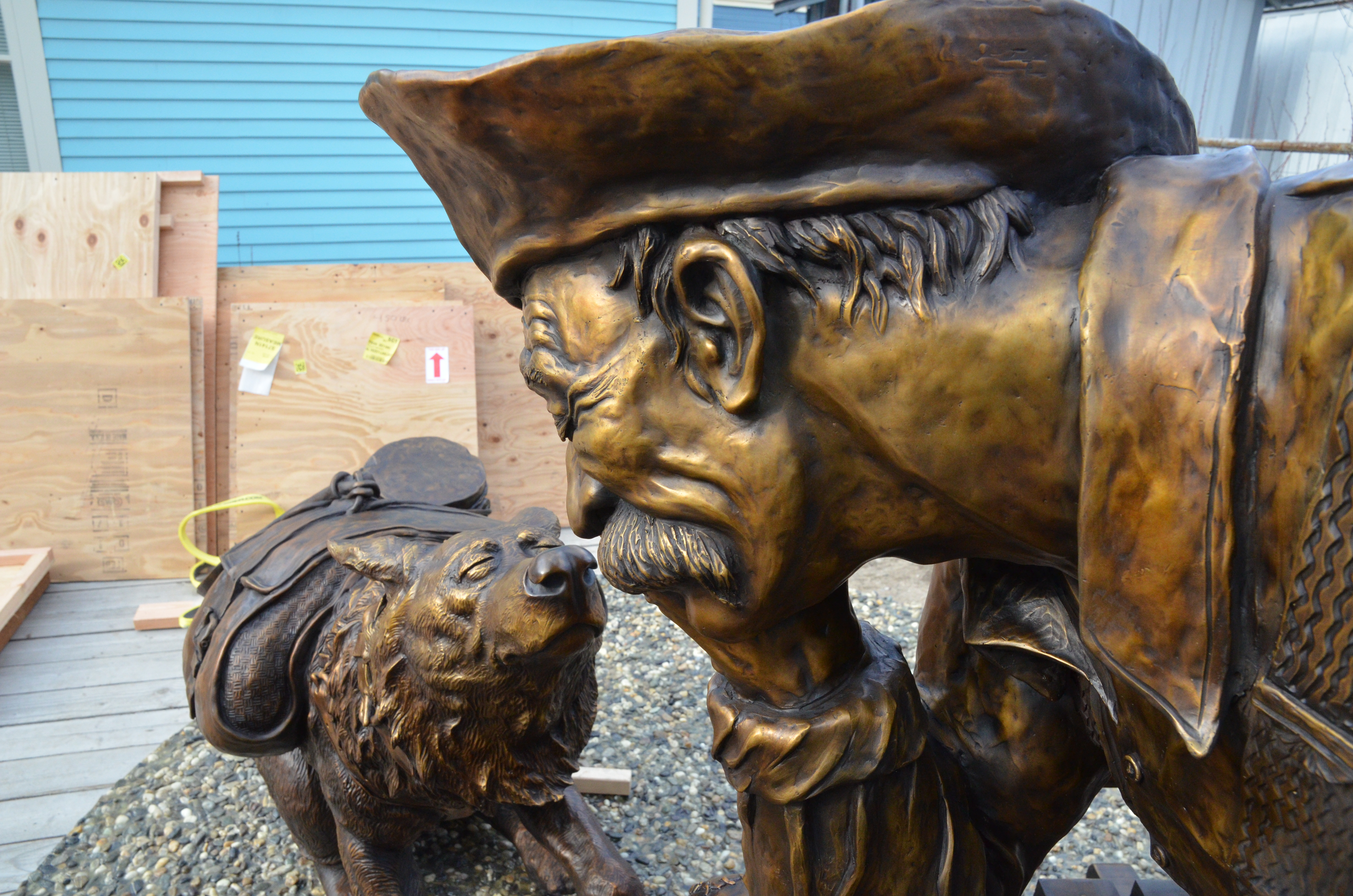 Close photo of bronzed sculpture of a man and a dog