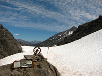 Snowy mountain pass with a sign and artifact in the foreground. Snowy mountain pass with a sign and artifact in the foreground.