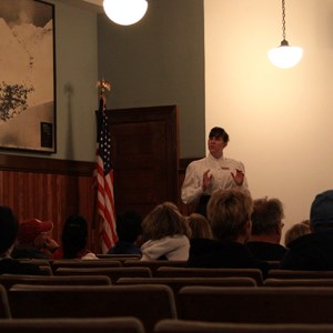 A costumed person talks to people in a theater
