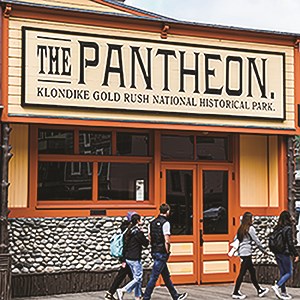 People walking by the closed doors of the Pantheon Saloon