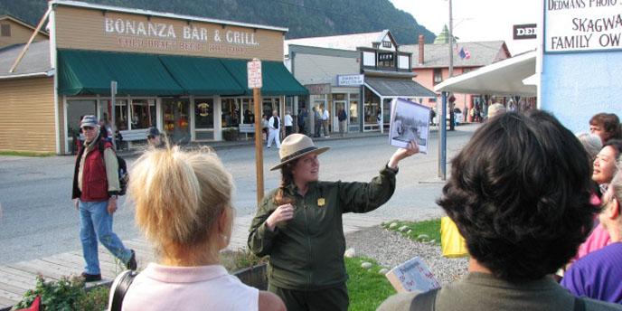 A ranger shows historic photos on a town tour A ranger shows historic photos on a town tour