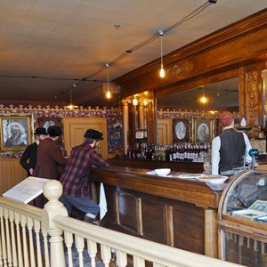 Manikins behind a railing at an old time bar