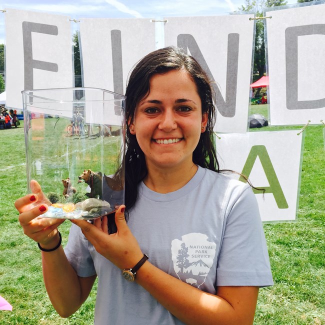 28935013096_4ae0f89440_o A woman wearing an NPS arrowhead shirt smiles holding a small terrarium.