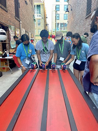 People standing at the end of the table playing rickshaw.