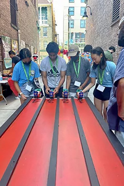 People standing at the end of the table playing rickshaw.