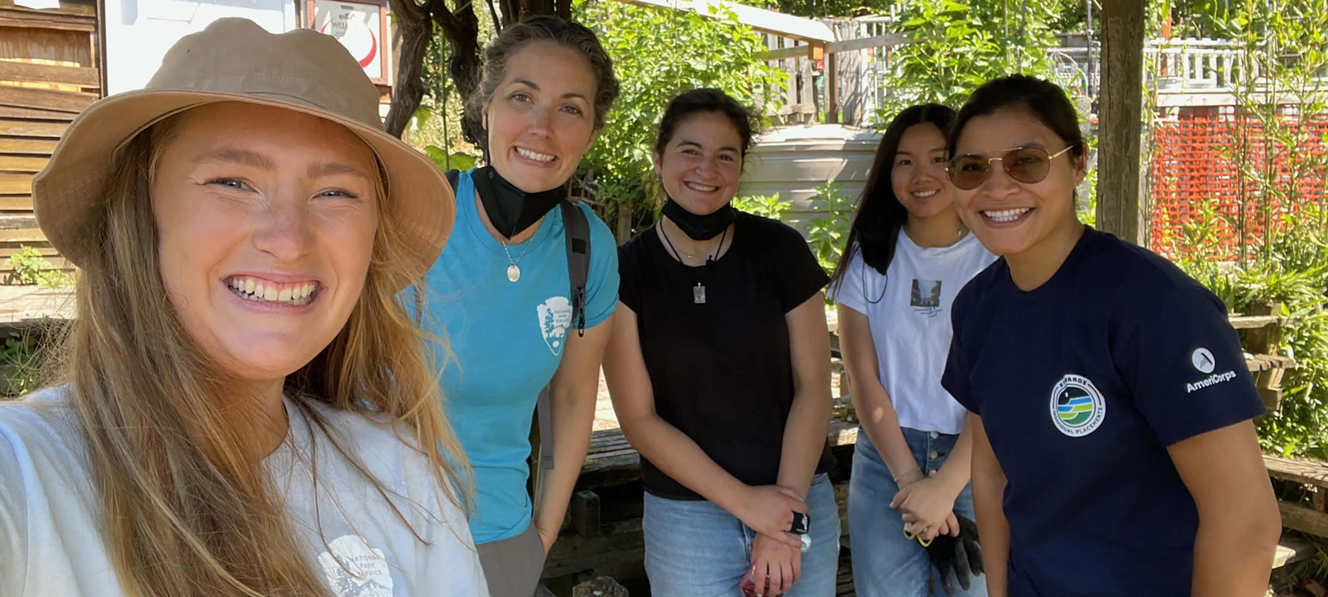 Four people smiling in a garden.