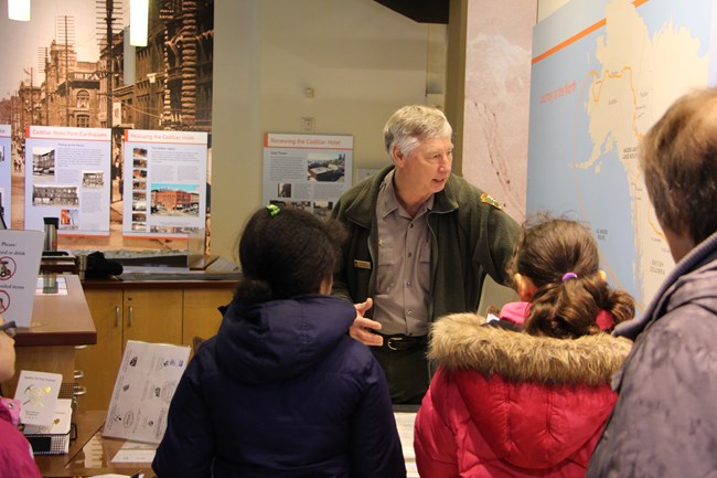 Ranger referring to a wall map while speaking with students.