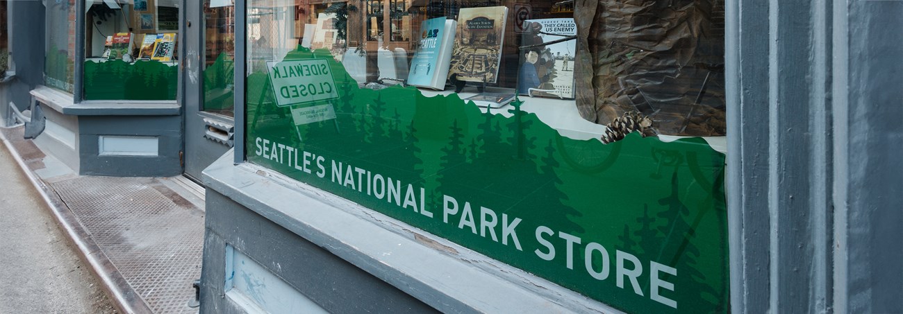 The exterior of a display window with blue trim and words reading Seattle’s National Park Store.