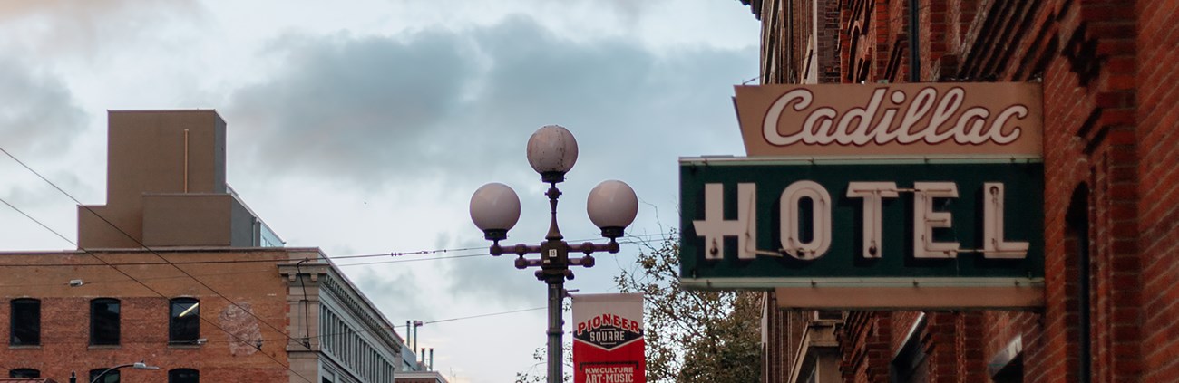 A street lined with brick buildings and a sign that reads Cadillac Hotel.