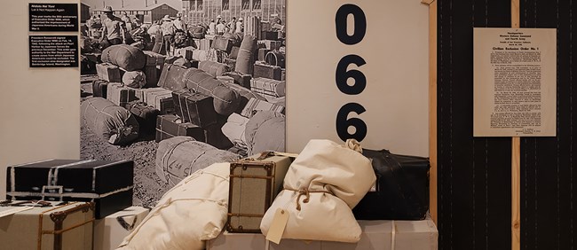 Luggage stacked on the floor next to a black and white photo on the wall.