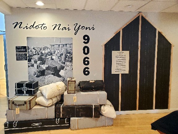 Luggage stacked on the floor next to a black and white photo on the wall.