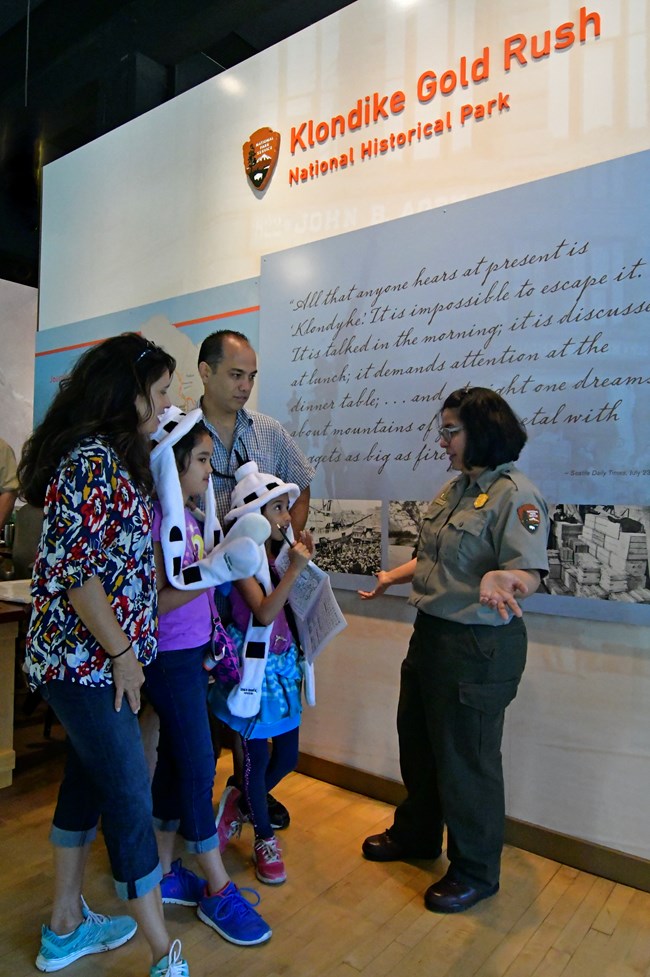 Ranger chatting with a family of four in the visitor center Ranger chatting with a family of four in the visitor center