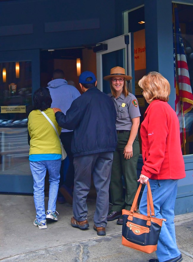 Ranger holding door for incoming visitors. Ranger holding door for incoming visitors.