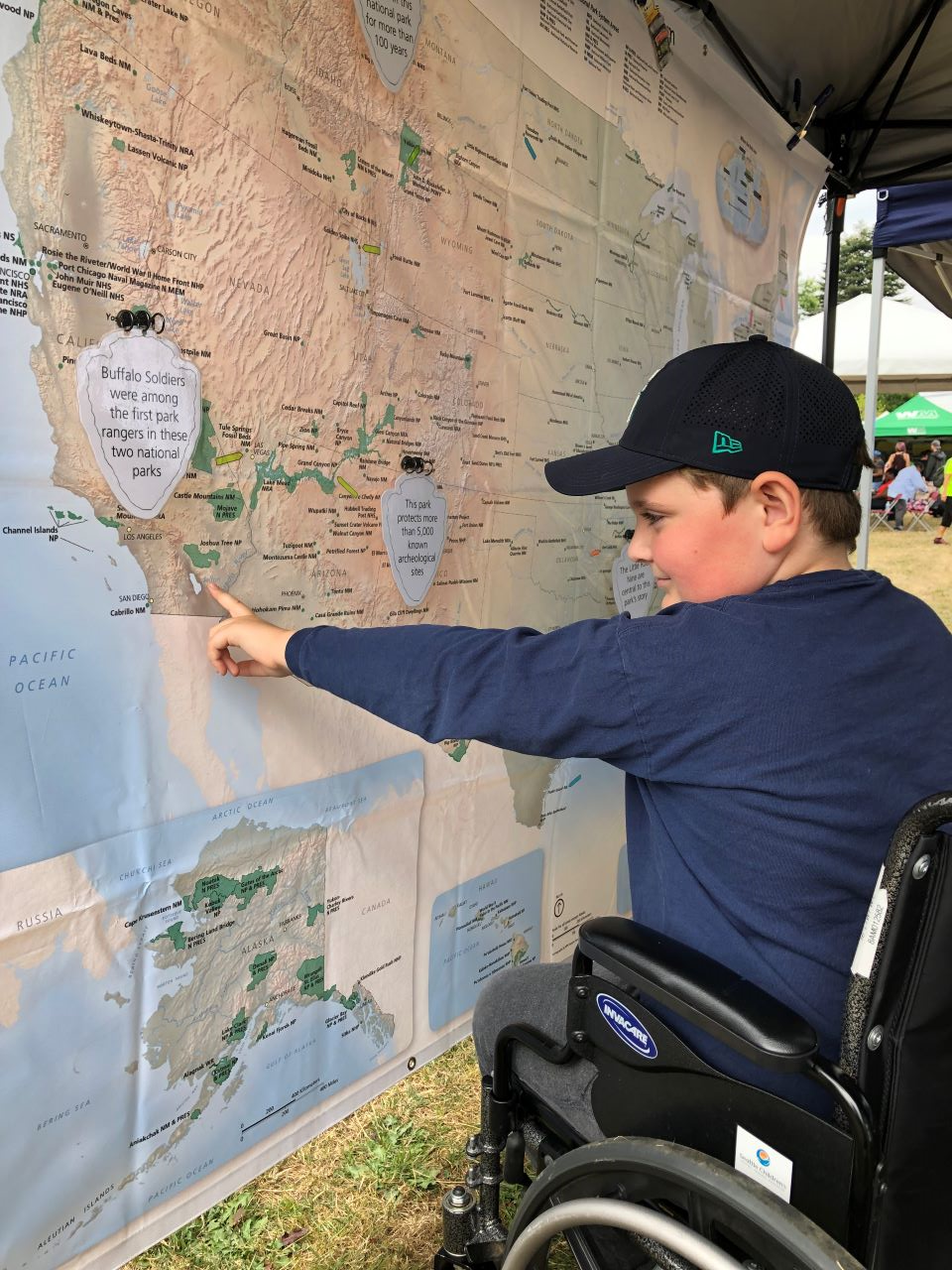 A person sitting in a wheelchair pointing to a map