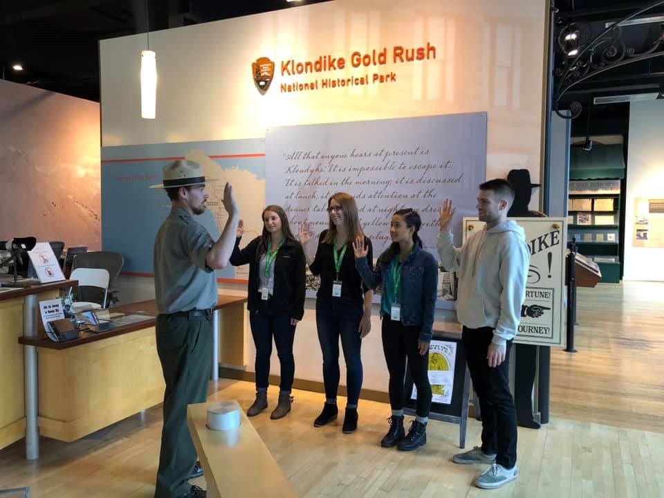 a ranger swears in four junior rangers