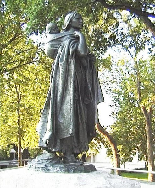 A statue of Sacagawea with her baby son wrapped in a blanket off her back.
