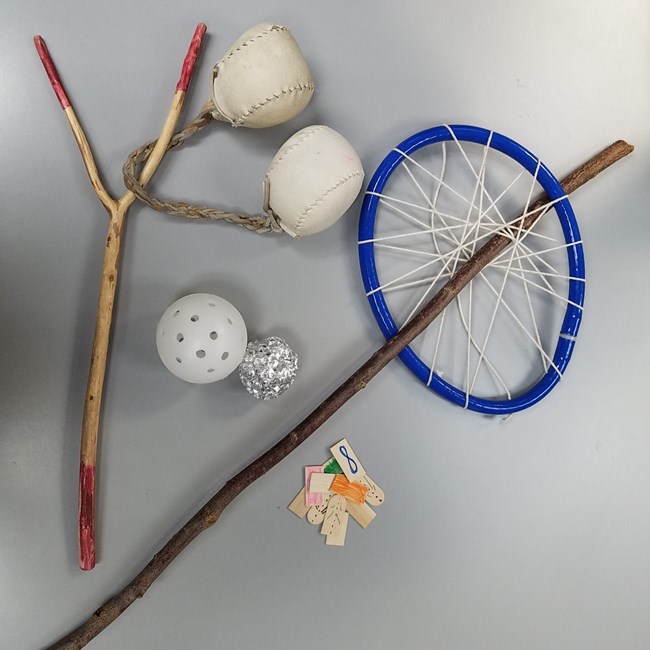 Native american games made with modern materials like baseballs, wooden chips, and tinfoil.