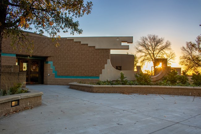 An image of the front of our visitor center entrance with an eagle made from bricks