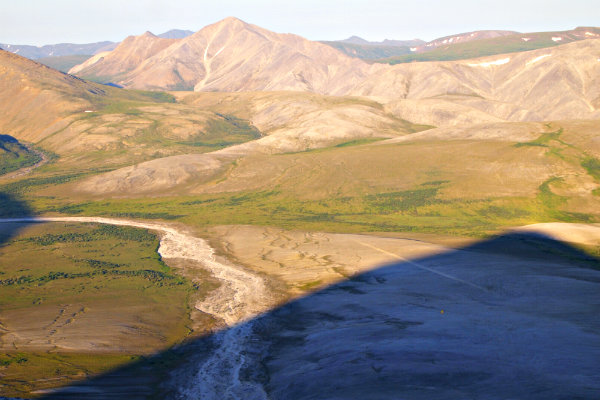 mountains and tundra with a rocky landing strip in the foreground