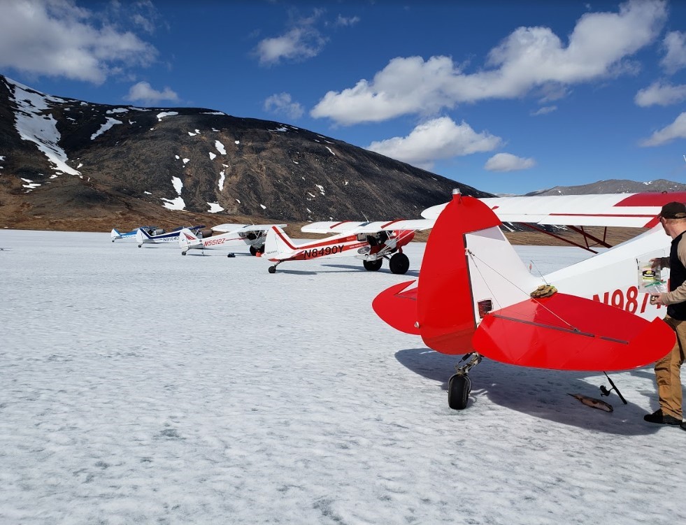row of small planes on a frozen lake