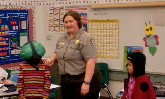 Park ranger in classroom with two students in insect costumes Park ranger in classroom with two students in insect costumes