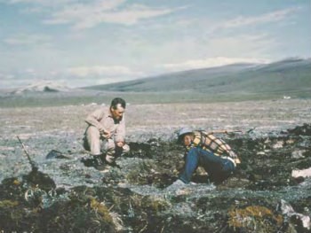 two men kneeling on the ground working