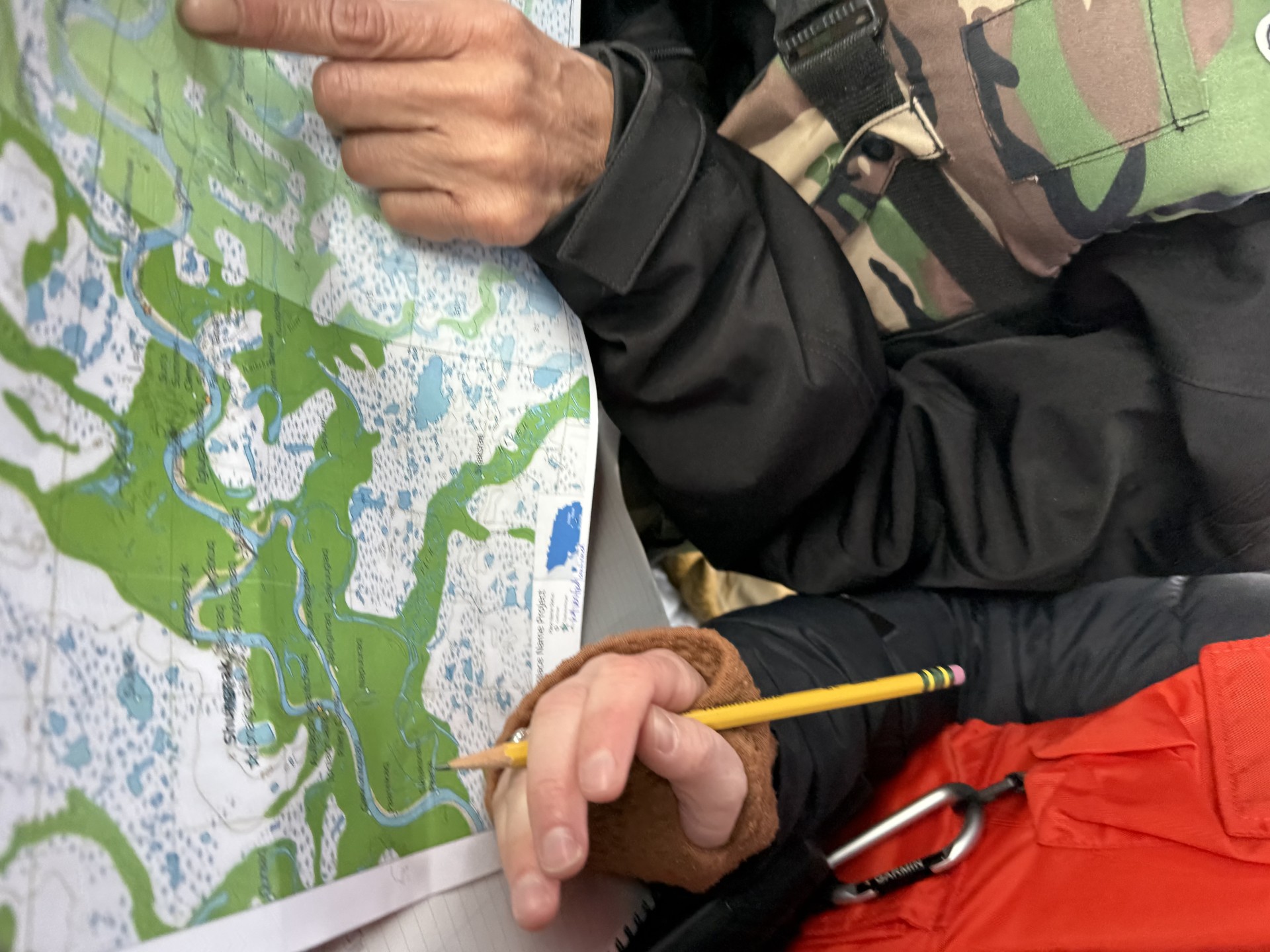 Finger pointing at a map of the Upper Kobuk River