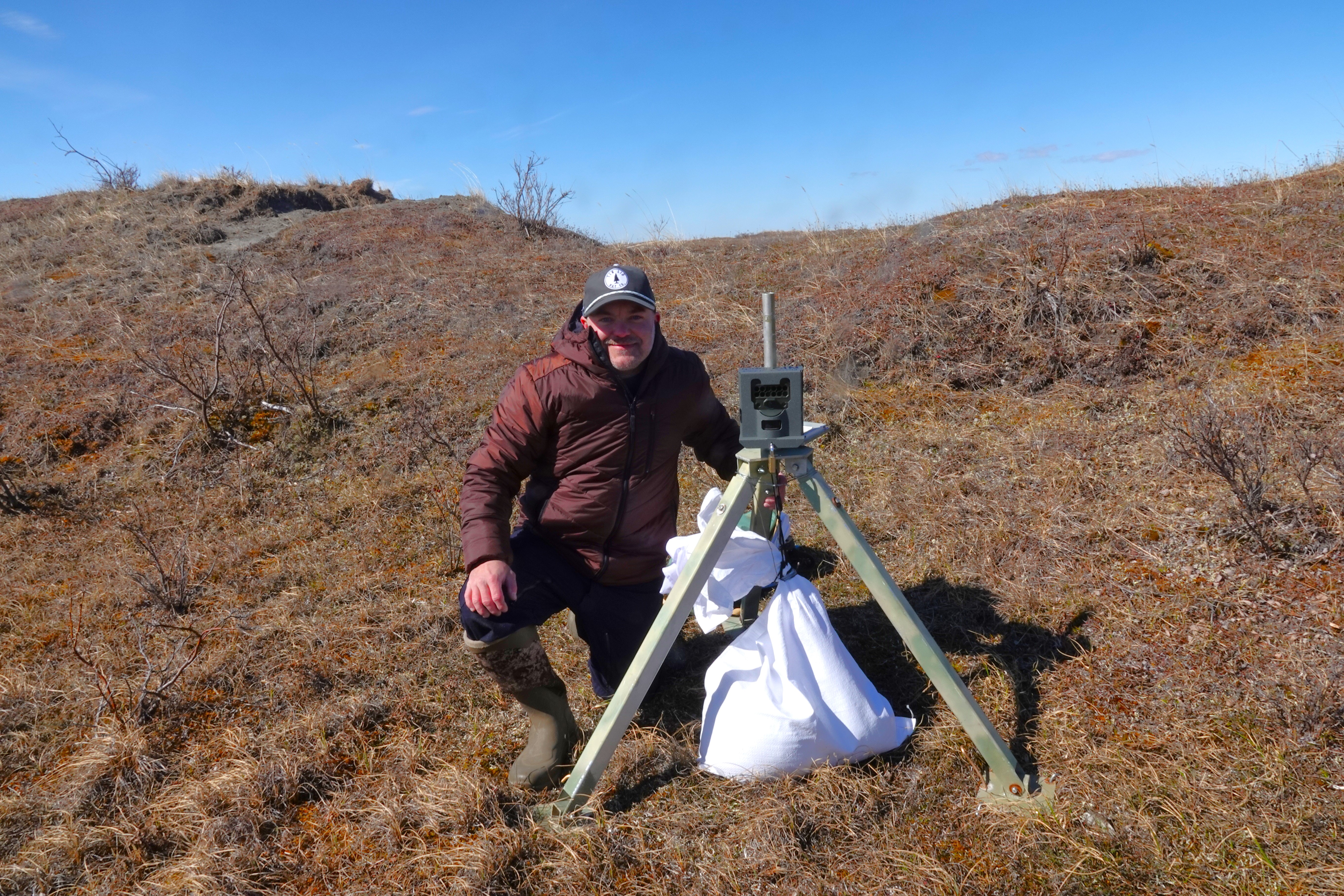 Dr Raime Fronstin with a timelapse camera on the tundra.