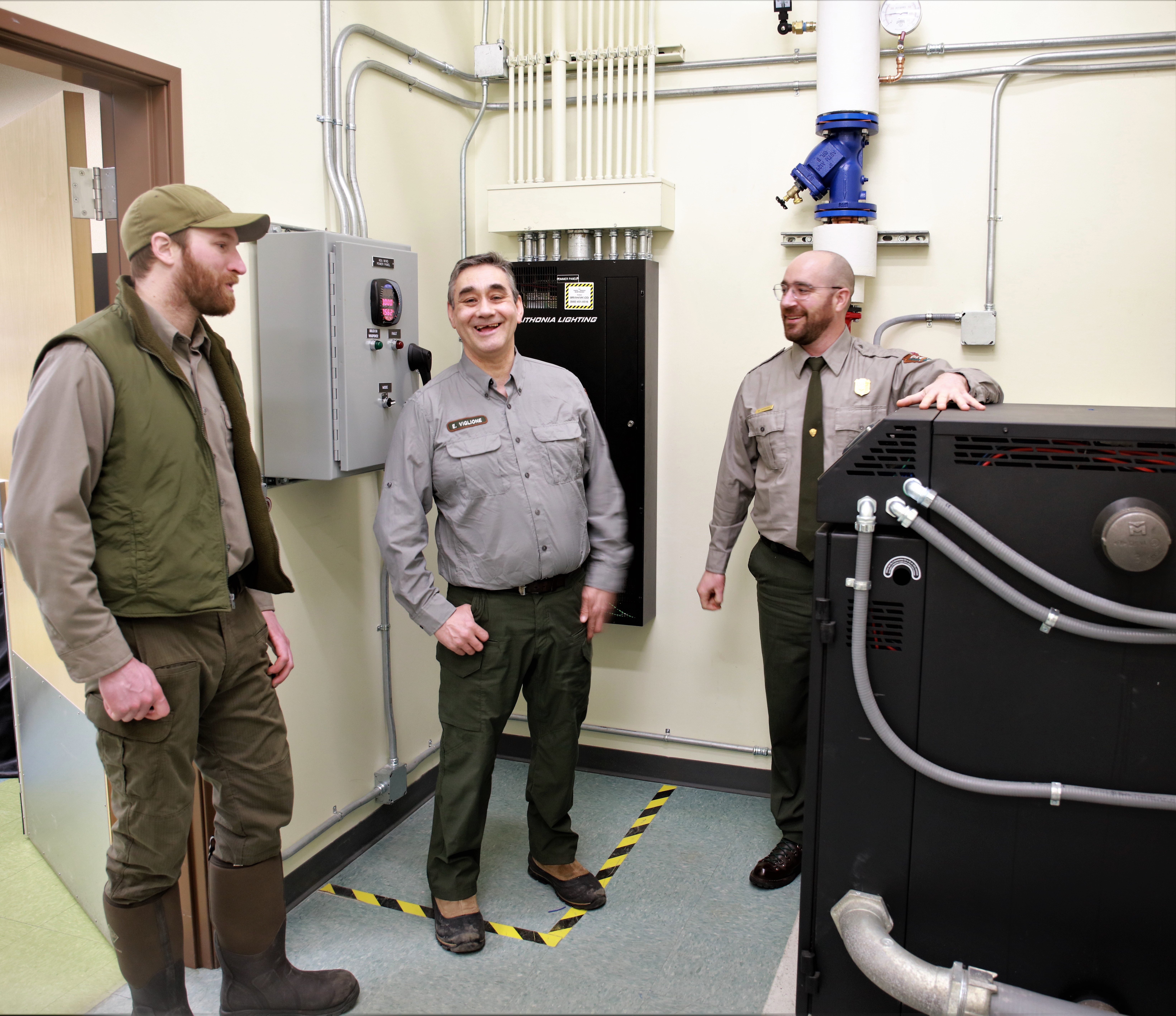 NPS employees stand in front of the new boiler powered by wind energy. NPS employees stand in front of the new boiler powered by wind energy.