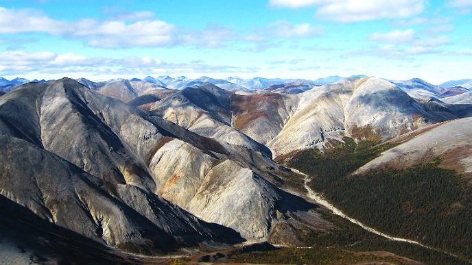 multiple mountain peaks stretching to the horizon under a blue sky