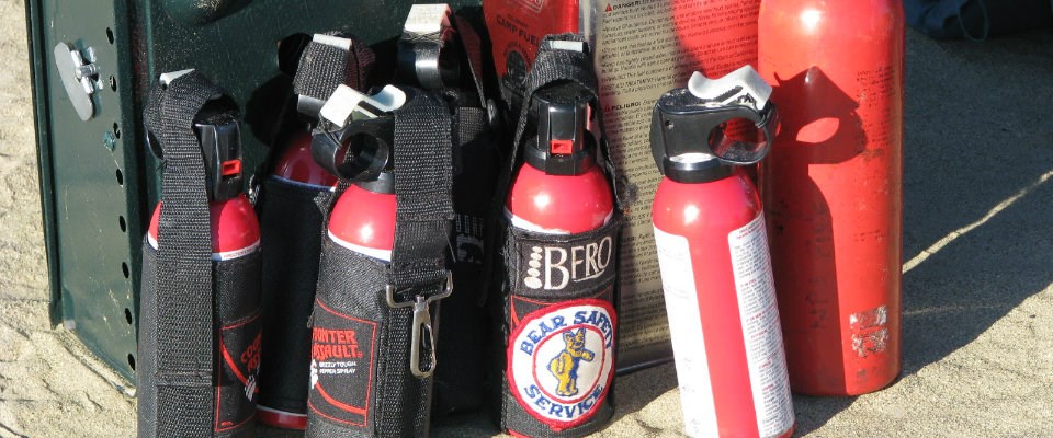 multiple red aerosol cans on the sand