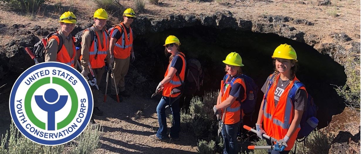 Youth Conservation Corps crew pauses near a cave during trail maintenance work.