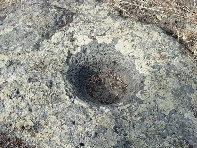 A circular depression in a stone