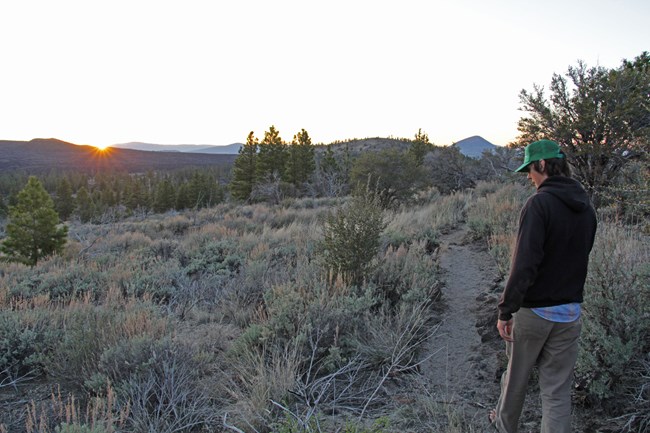 Visitor hiking along the Big Nasty Trail at sunset.