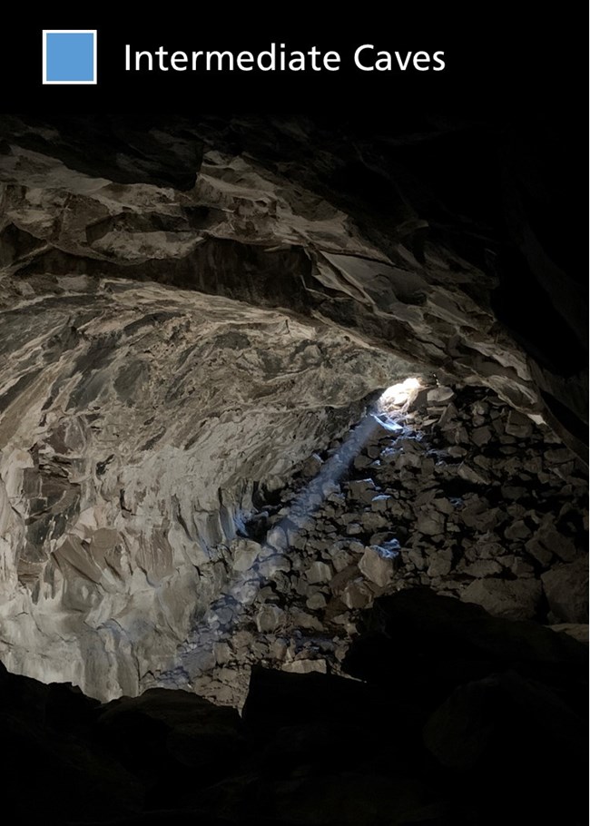 An intermediate cave with a sloping and rocky floor and a tighter entrance