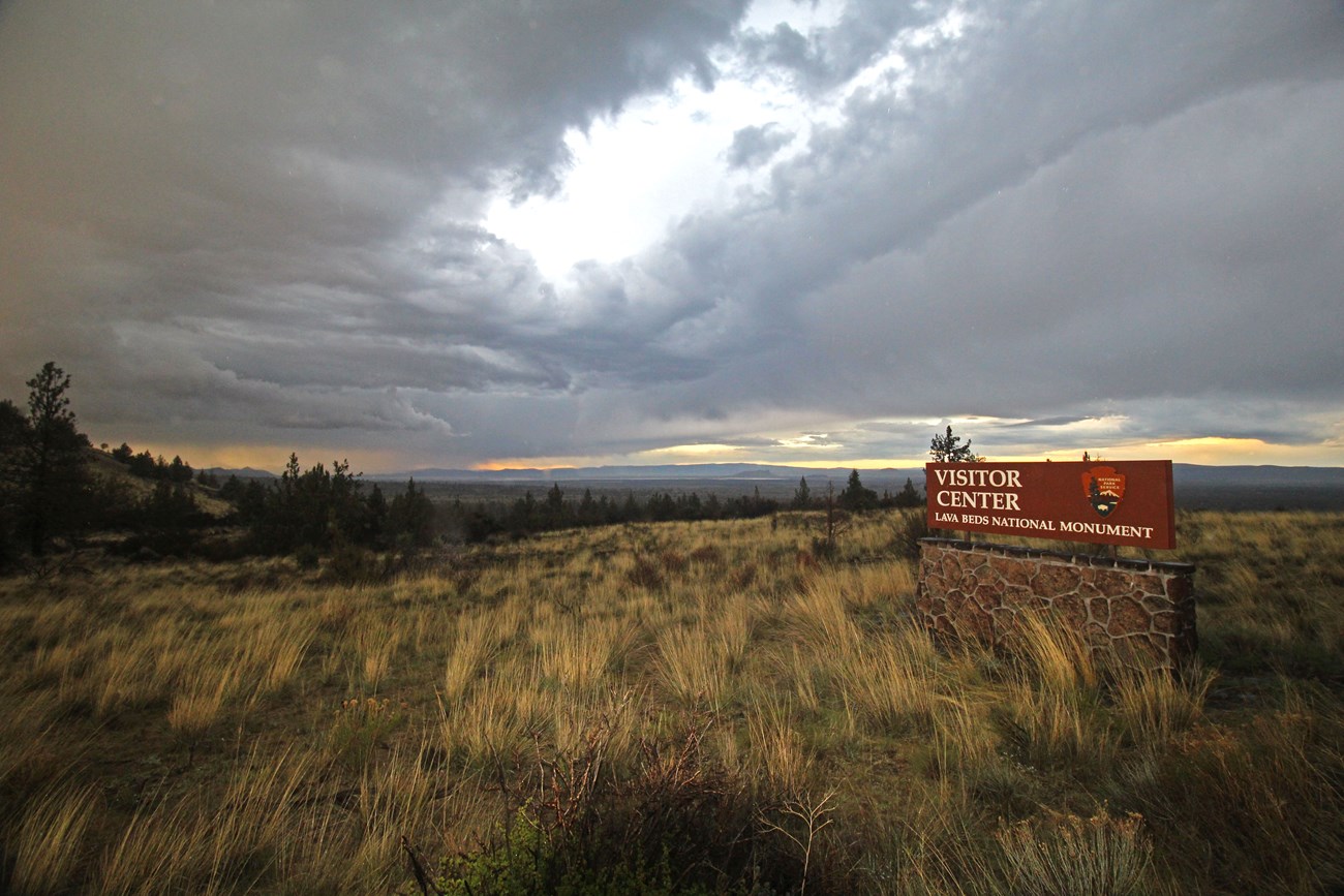 The Visitor Center sign under a stormy sky.