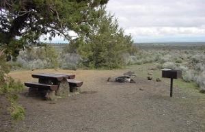 campsite with table, fire pit and cooking grill